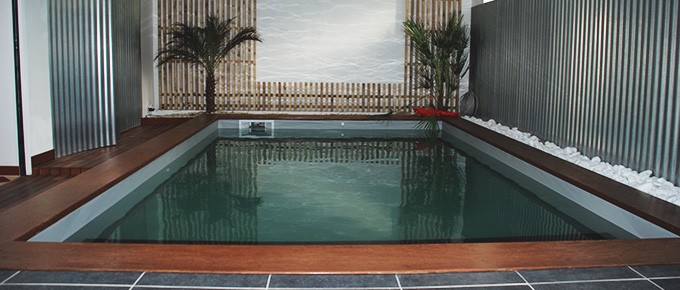 Mini piscine intérieure avec volet sous marche en pierre